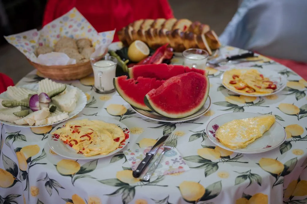 Masă de vară cu brânzeturi, omletă, pâine și pepene la Familia Buga