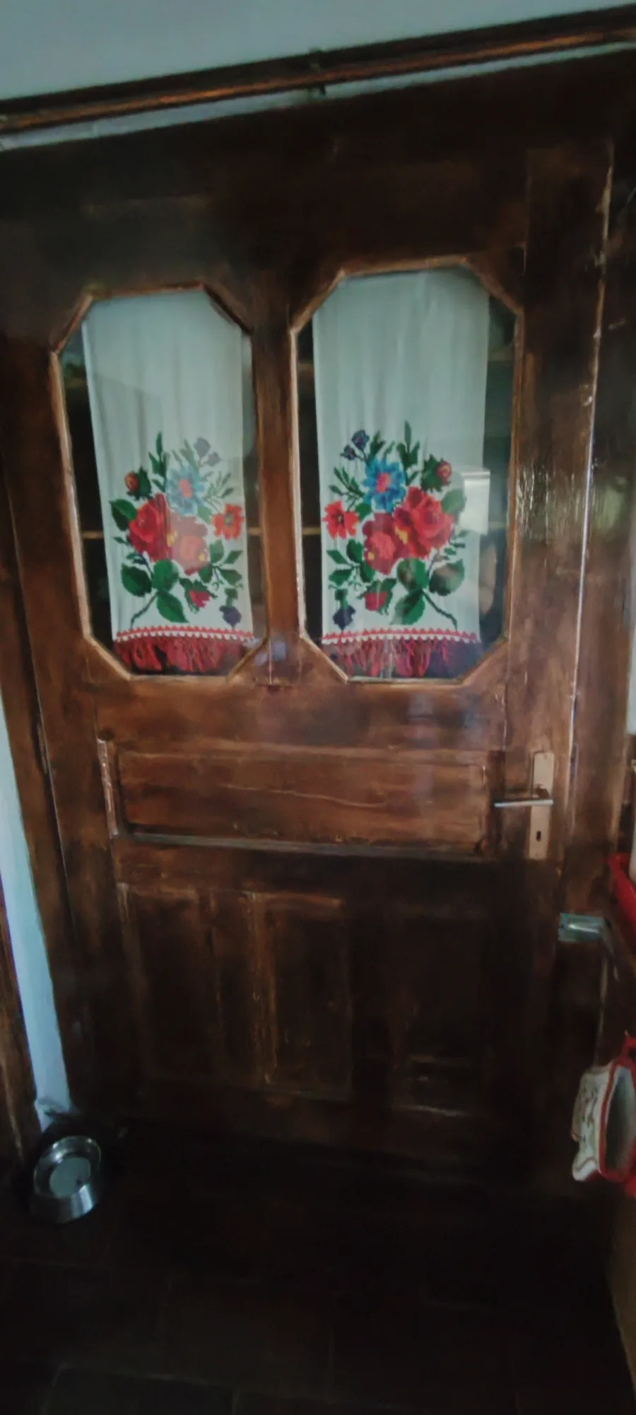 Ușă din lemn pictată cu flori în casa de la La Poieni