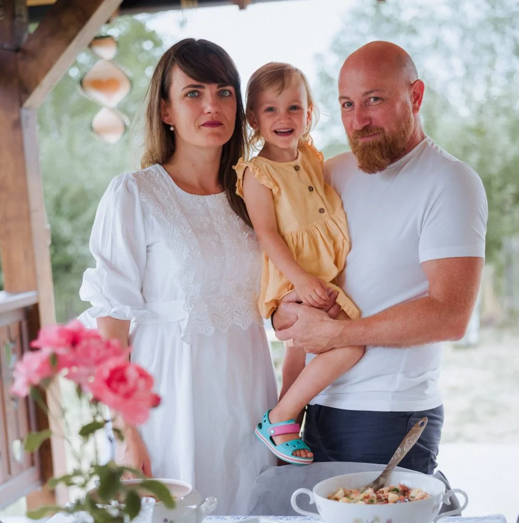 Familia gazdă lângă masa pregătită pentru oaspeți