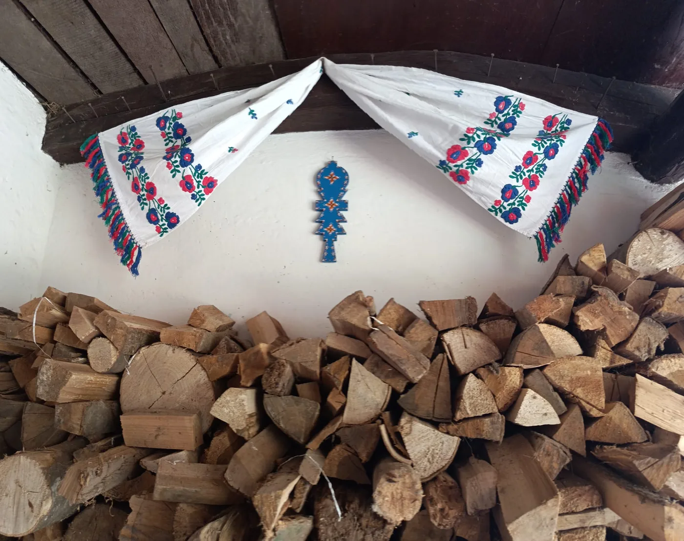 Casa din Săsăuș decorată cu ștergare, lângă lemnele pentru foc